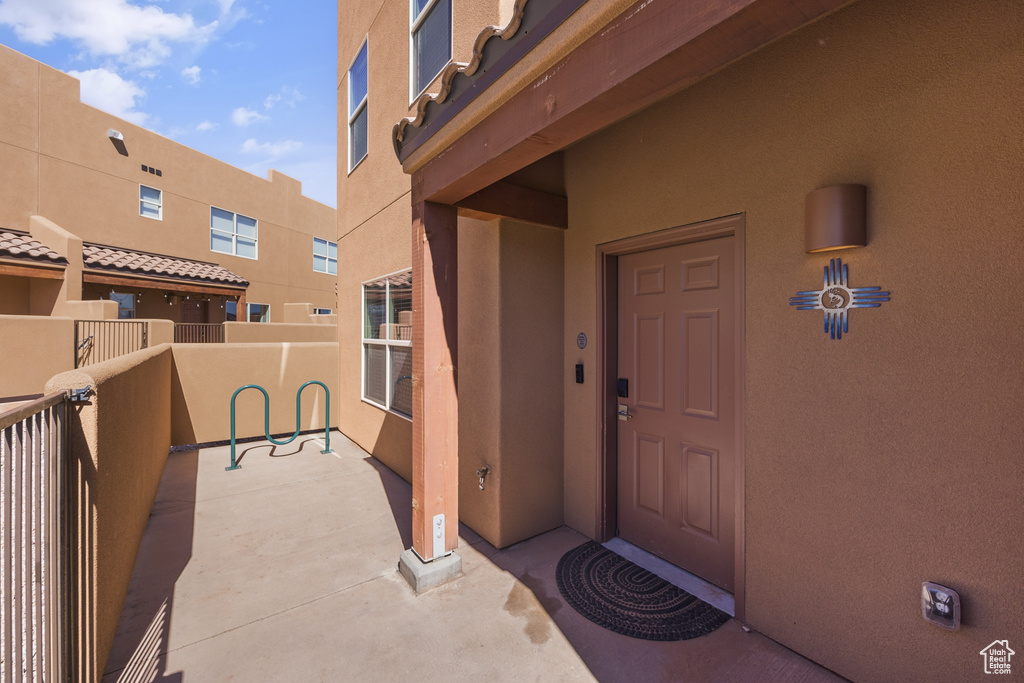 Entrance to property with stucco siding and a balcony