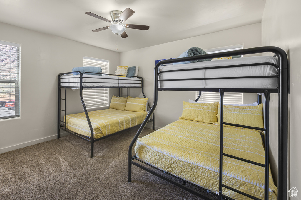 Carpeted bedroom featuring baseboards and ceiling fan