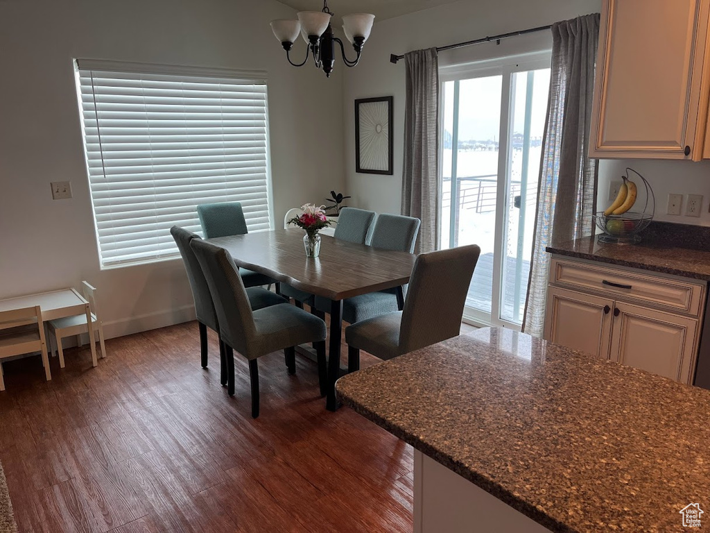 Dining space featuring dark wood-style flooring and a chandelier