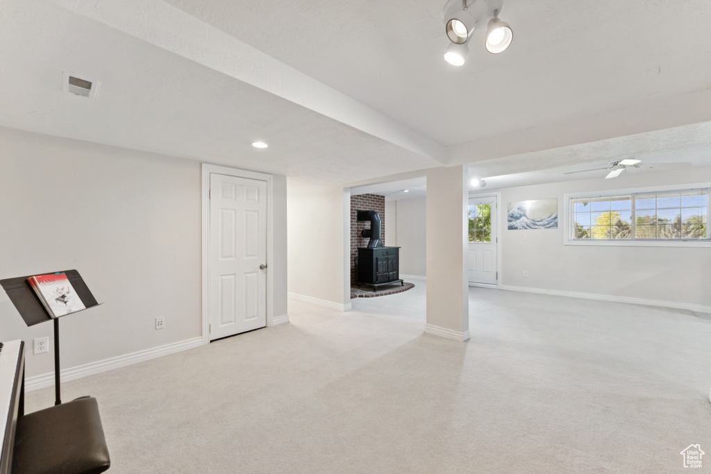 Below grade area with a wood stove, carpet floors, and recessed lighting