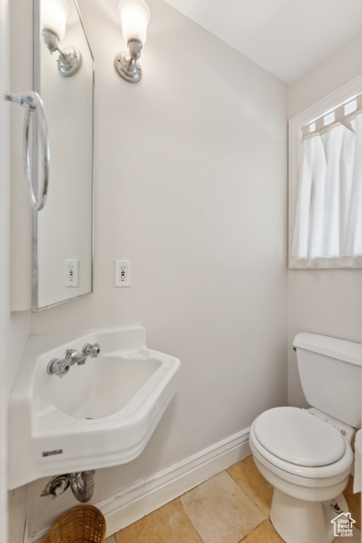 Half bath featuring toilet and baseboards