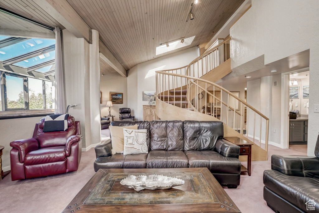 Living room with stairs, carpet floors, a skylight, wooden ceiling, and vaulted ceiling