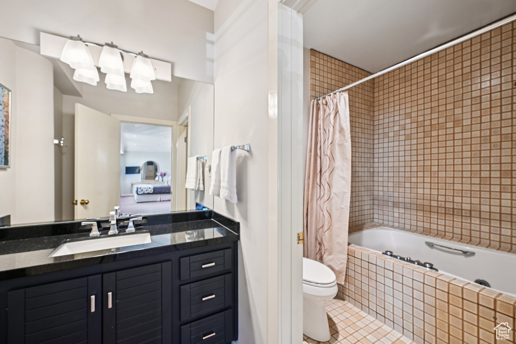 Full bath with tile patterned flooring, vanity, and tiled shower / bath combo