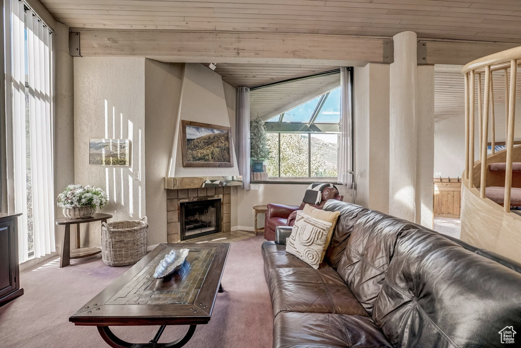 Living area featuring carpet floors, wooden ceiling, and a fireplace