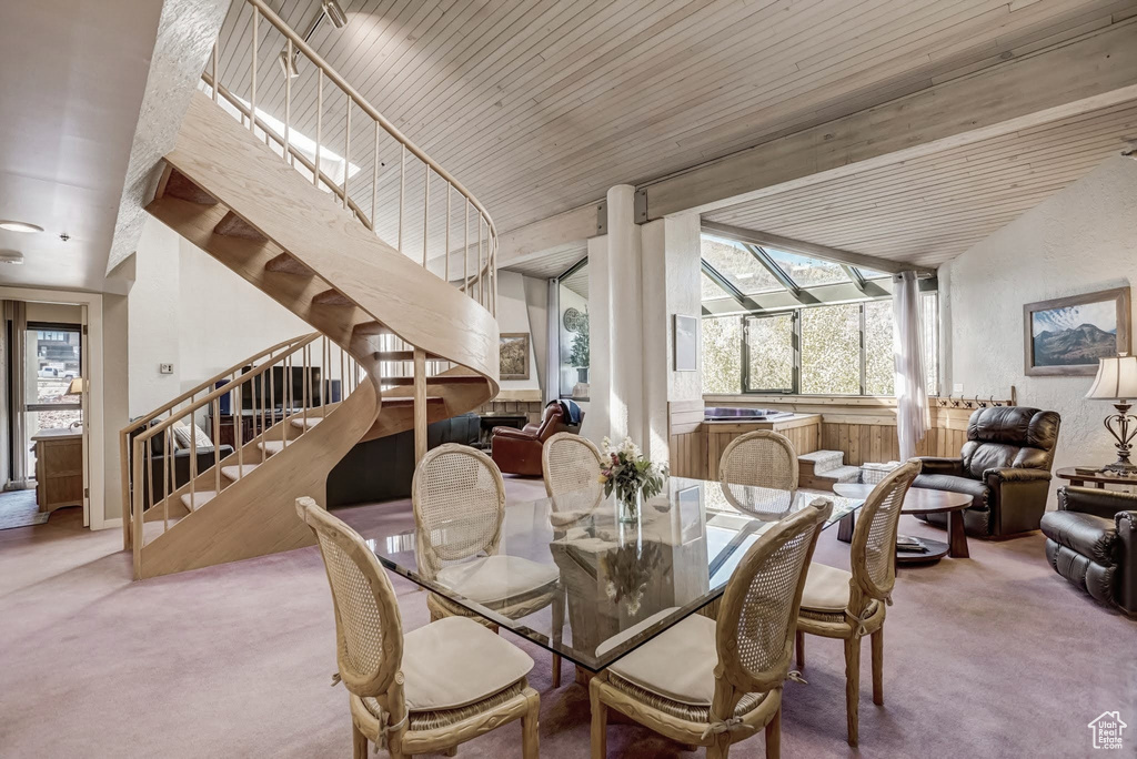 Carpeted dining room featuring stairs and vaulted ceiling