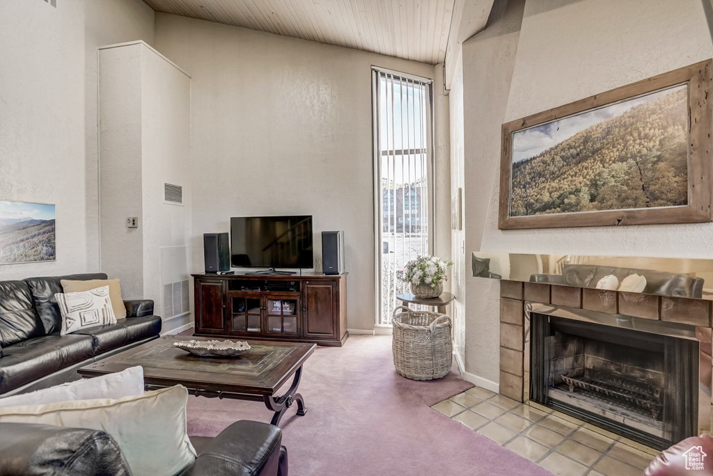 Carpeted living room with a tile fireplace and a textured wall