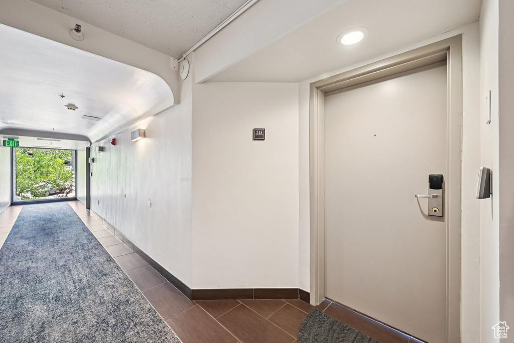 Hall featuring tile patterned flooring and baseboards