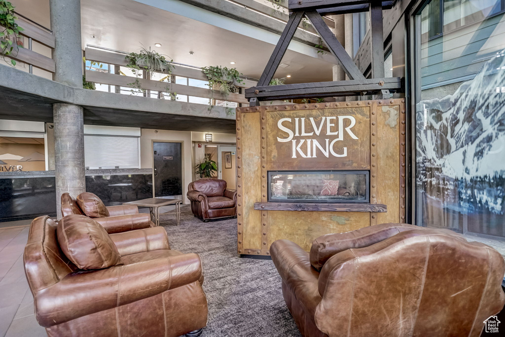 Living room featuring a high ceiling, carpet floors, and a fireplace