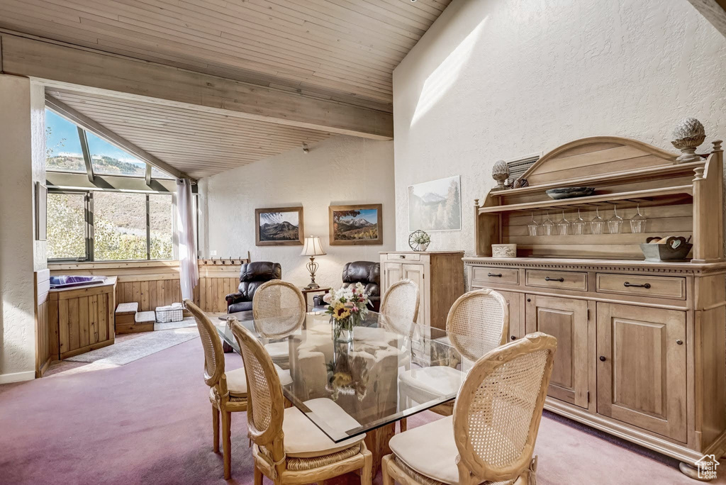 Dining room featuring light carpet, a textured wall, and wood ceiling