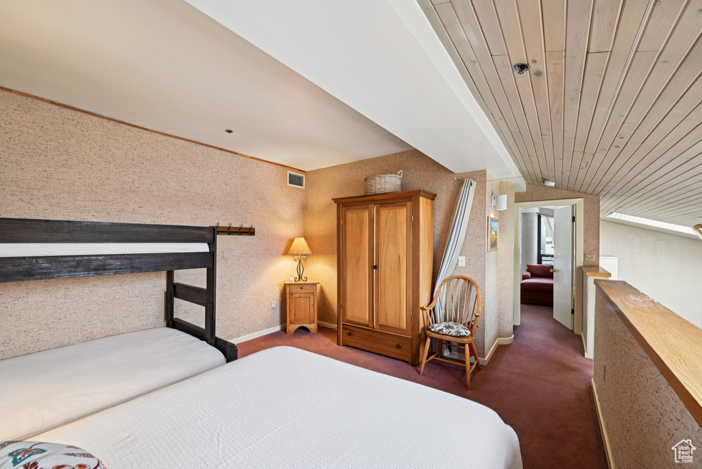 Bedroom featuring vaulted ceiling and dark colored carpet