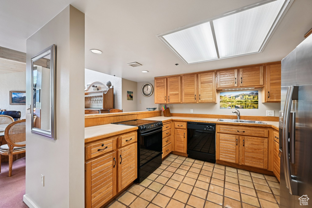 Kitchen with black appliances, light countertops, recessed lighting, and light tile patterned floors
