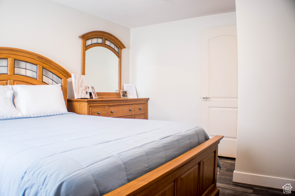 Bedroom featuring dark wood-style flooring and baseboards