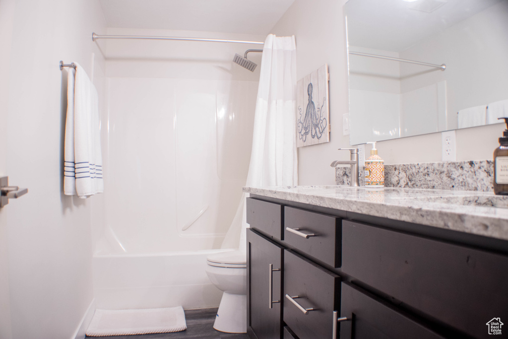 Full bathroom featuring vanity, shower / bath combination with curtain, and wood finished floors