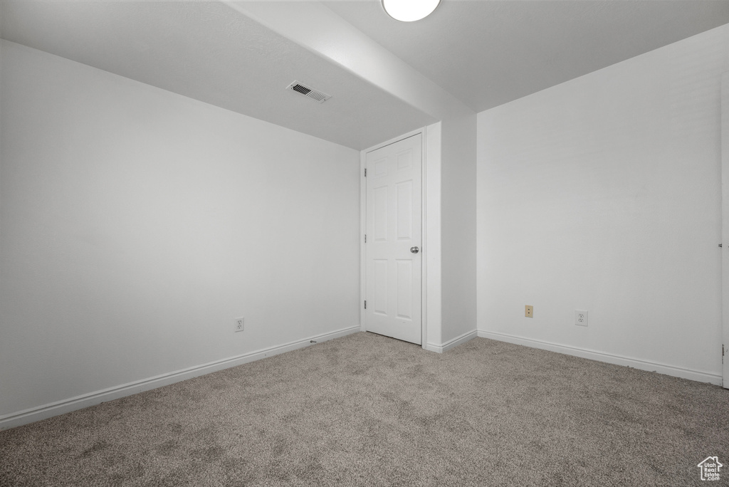 Spare room featuring light carpet and baseboards