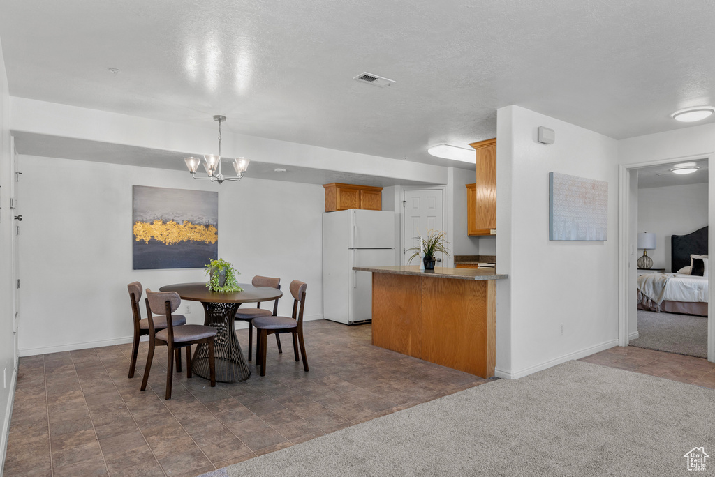 Dining area featuring a chandelier and baseboards