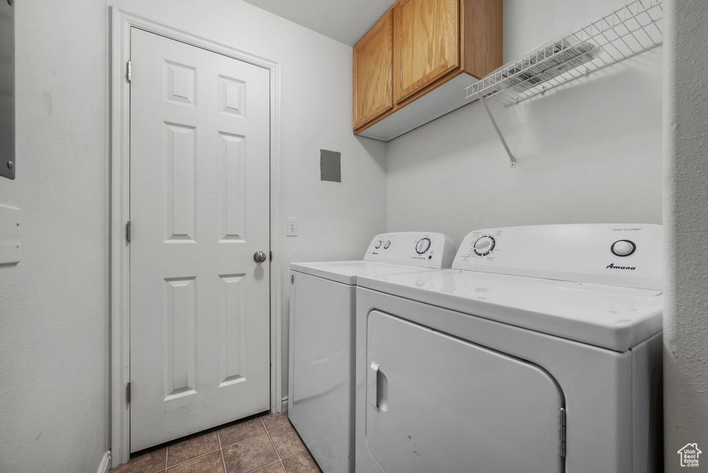 Washroom featuring cabinet space and washer and dryer