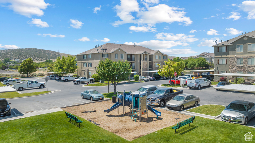 Communal playground featuring a yard, a residential view, and a mountain view