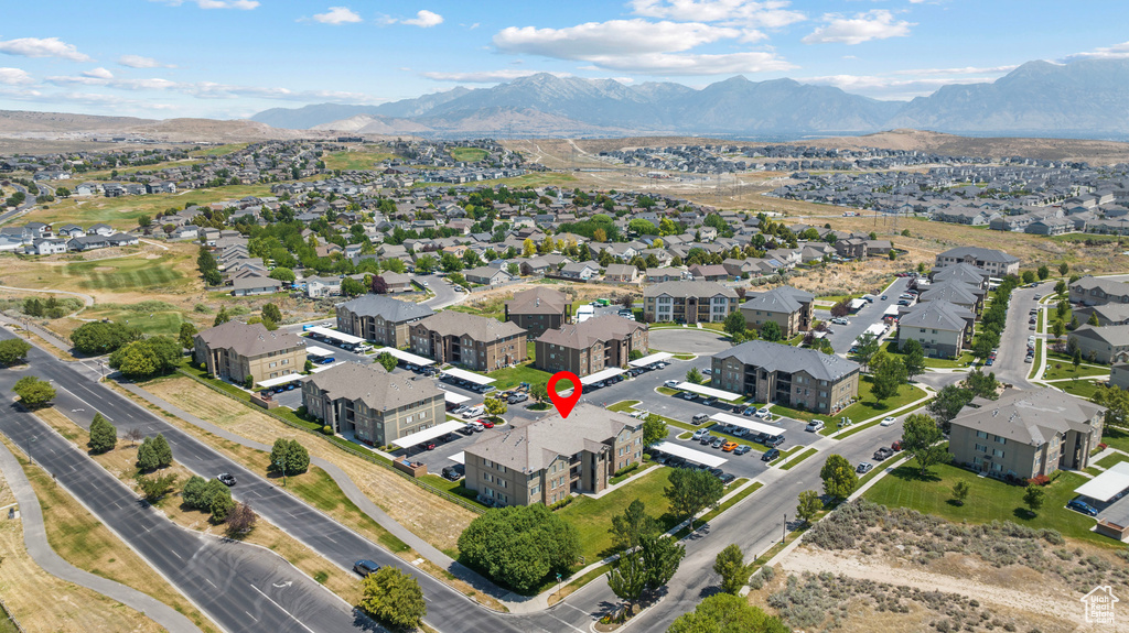 Aerial view of property and surrounding area featuring a mountainous background and nearby suburban area
