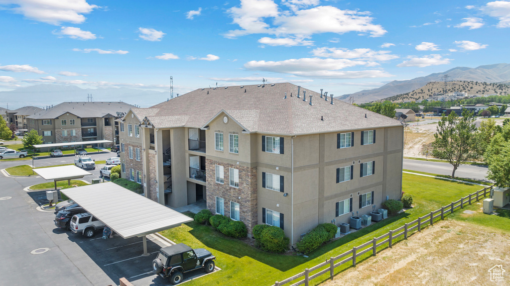 View of property with a mountain view, uncovered parking, and a residential view