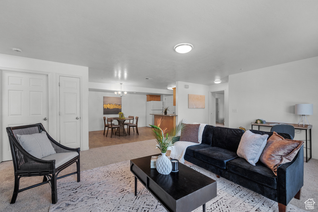 Living room featuring light colored carpet and a chandelier