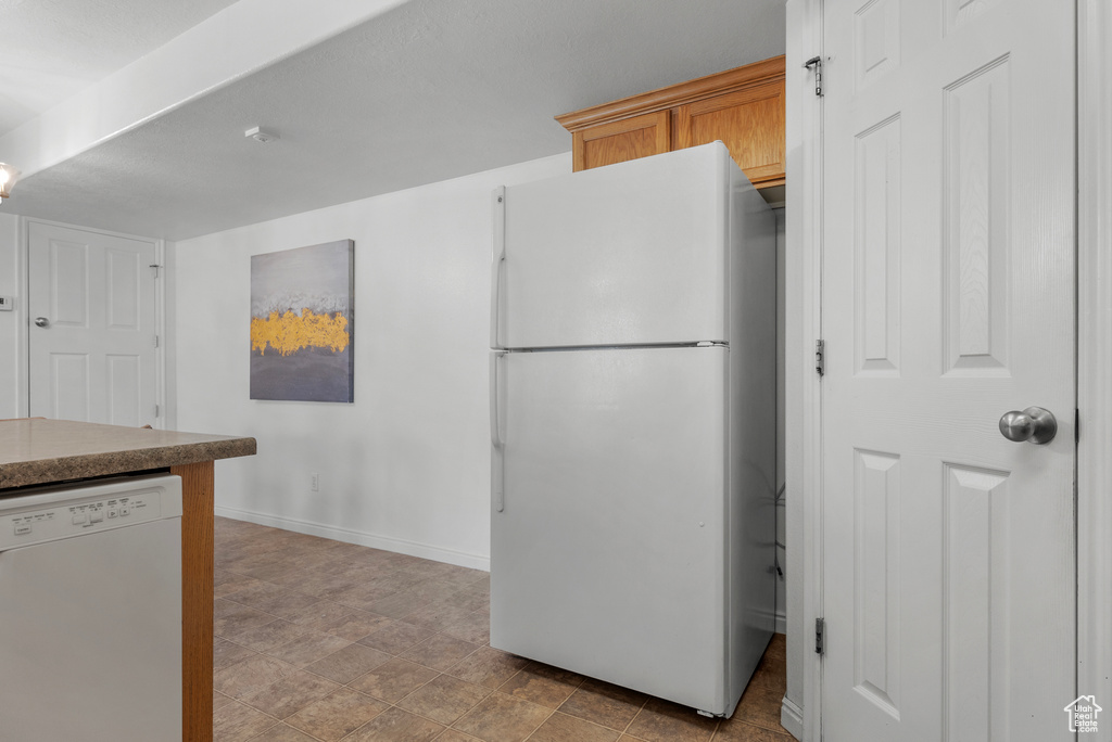 Kitchen with white appliances and baseboards