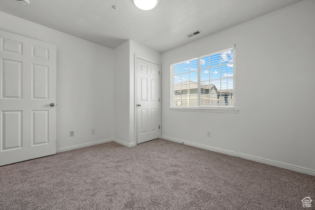 Unfurnished bedroom featuring carpet and baseboards
