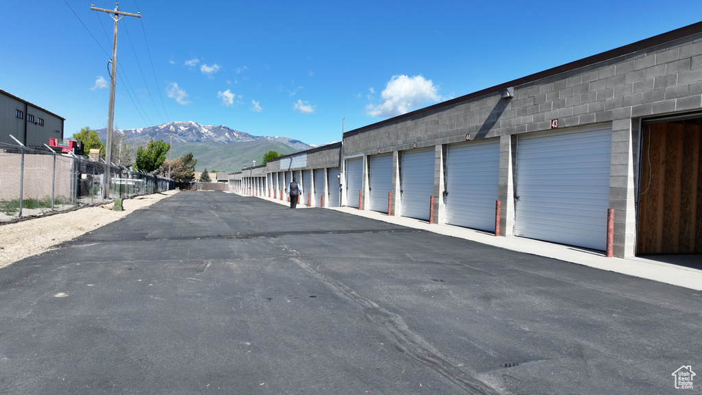 View of asphalt road featuring community garages and a mountain view