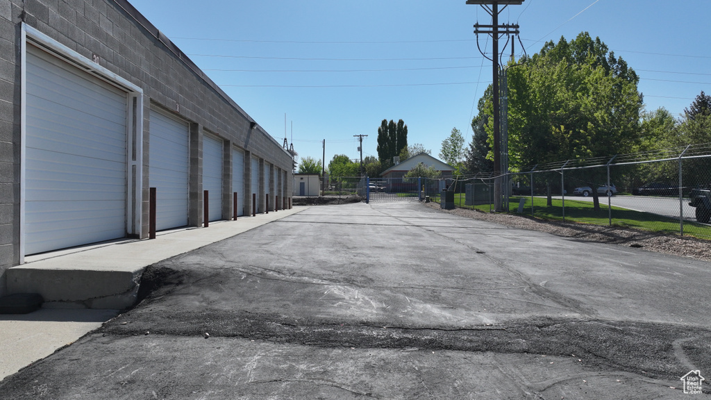 View of asphalt driveway featuring a gate
