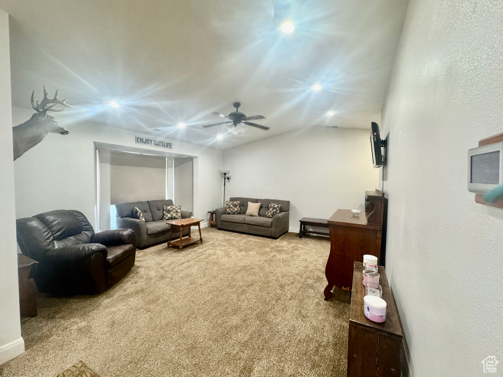 Carpeted living area featuring recessed lighting, a ceiling fan, and lofted ceiling