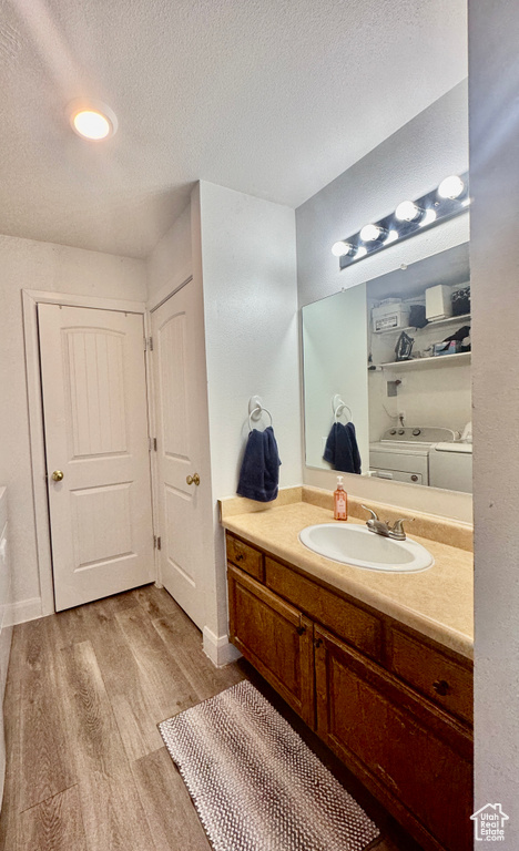 Bathroom with vanity, a textured ceiling, and wood finished floors