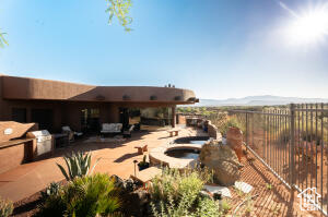 Rear view of house featuring an in-ground hot tub and a patio area
