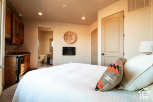 Bedroom featuring recessed lighting, a fireplace, arched walkways, and connected bathroom