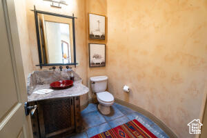Half bath with vanity and tile patterned flooring
