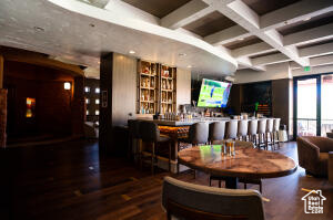 Interior space with coffered ceiling, wood finished floors, and beamed ceiling