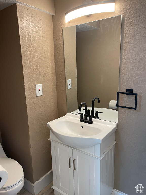 Bathroom with vanity and a textured wall