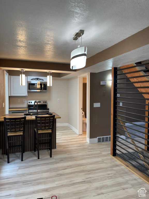 Dining space featuring light wood-style floors and a textured ceiling
