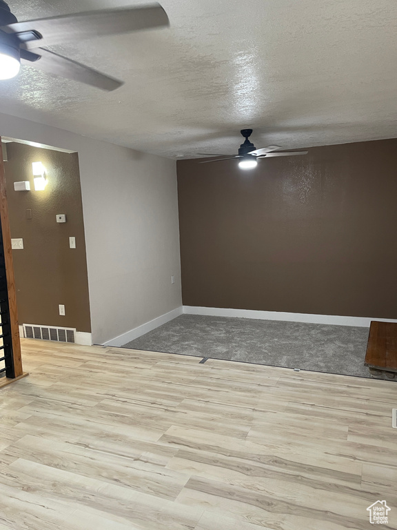 Spare room featuring ceiling fan, a textured ceiling, and wood finished floors