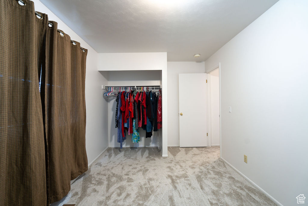 Unfurnished bedroom featuring carpet flooring and a closet