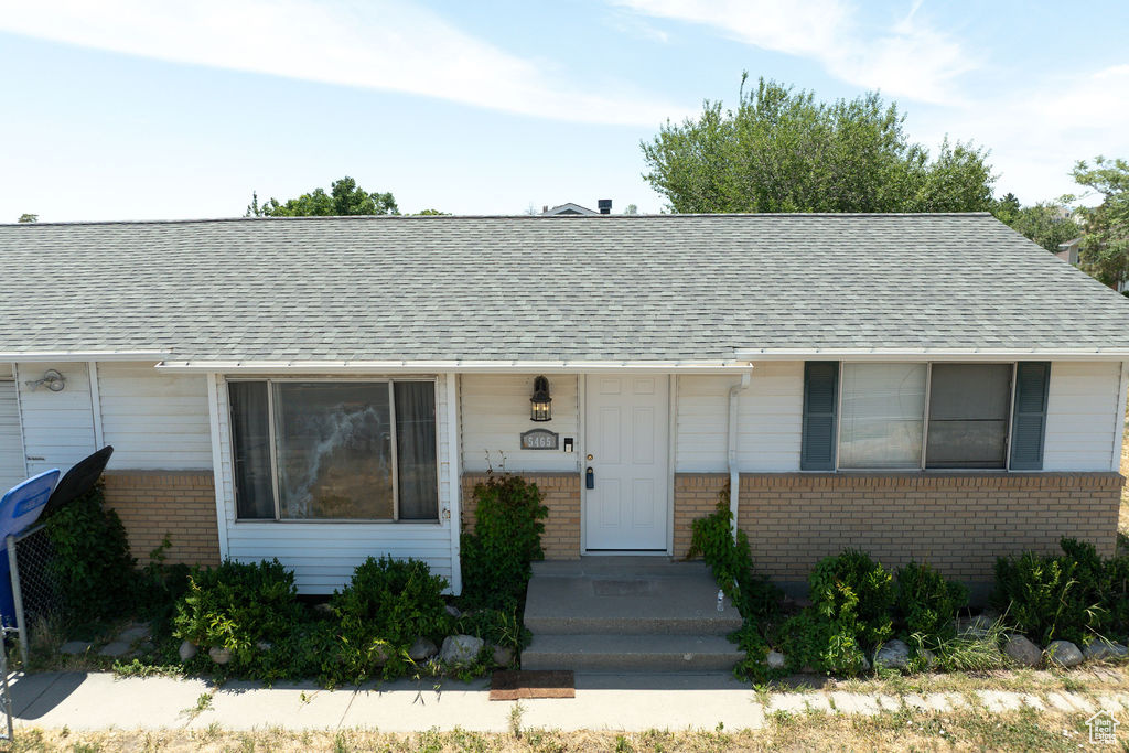View of front of home with brick siding and roof with shingles
