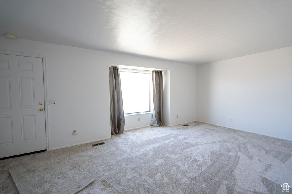 Empty room featuring carpet floors and a smoke detector