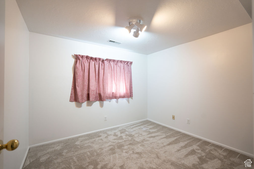 Carpeted empty room featuring baseboards