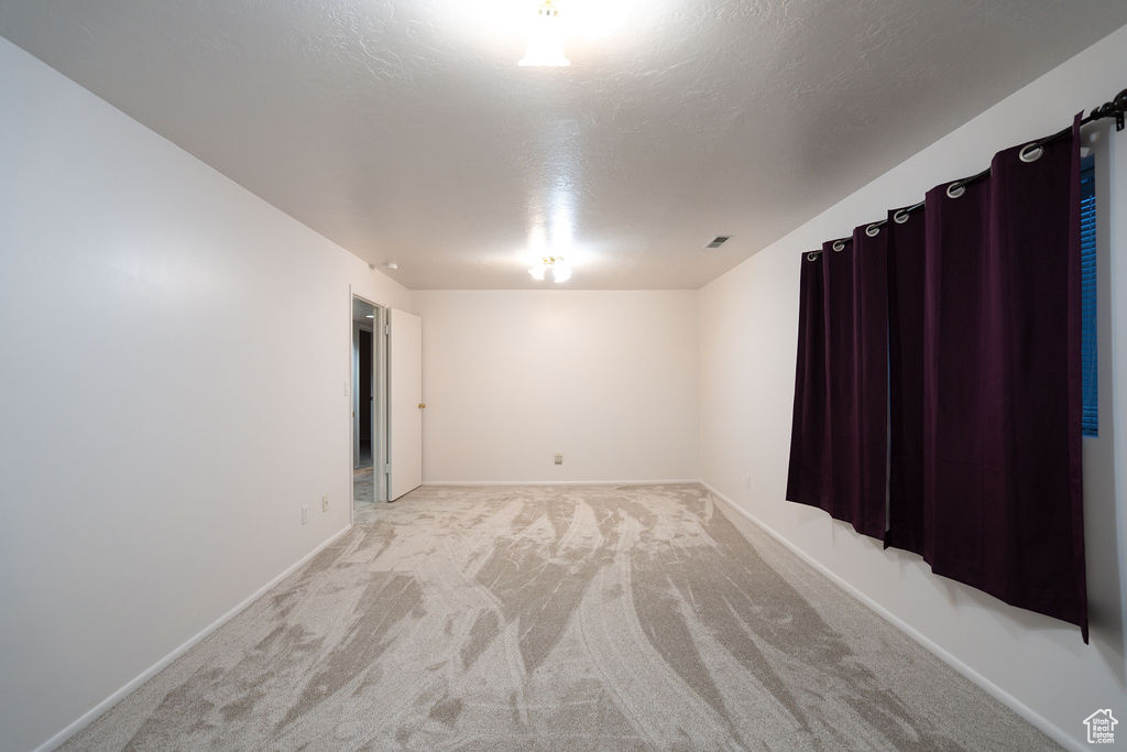 Spare room featuring light carpet and a textured ceiling