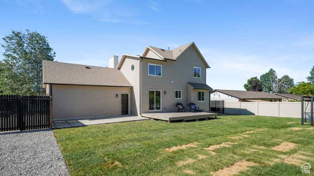 Back of house with a fenced backyard and a wooden deck