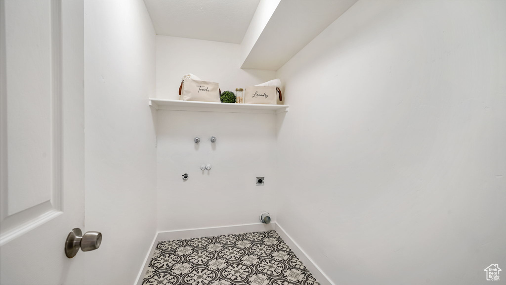 Laundry room featuring electric dryer hookup, tile patterned floors, and washer hookup