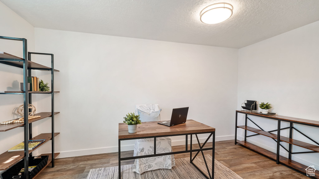 Home office with wood finished floors and a textured ceiling