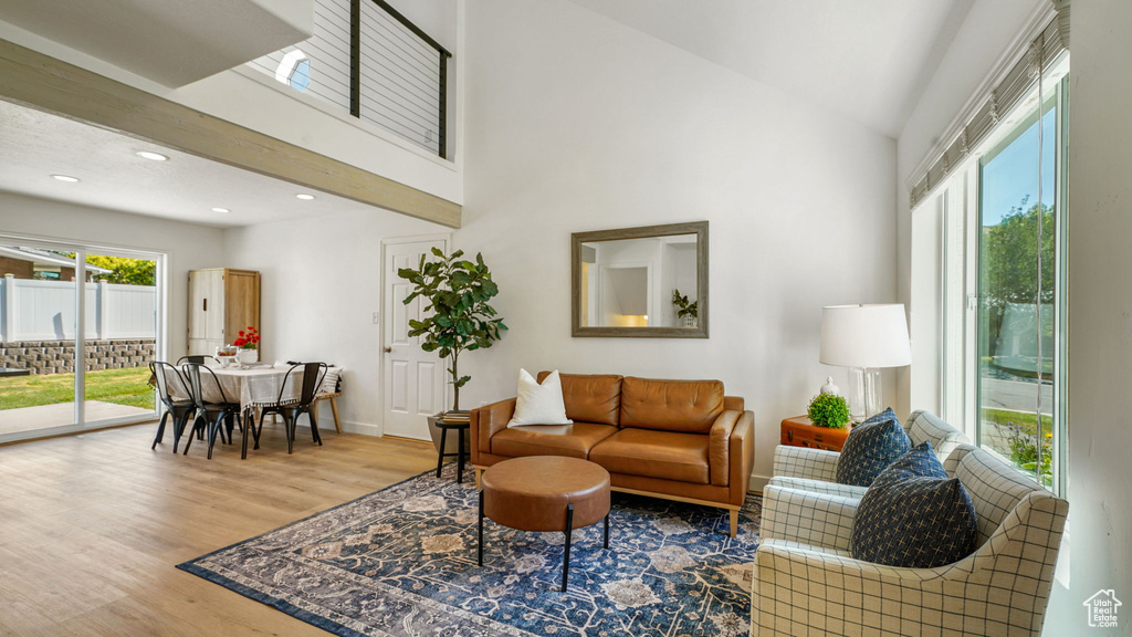 Living area with wood finished floors, recessed lighting, and high vaulted ceiling