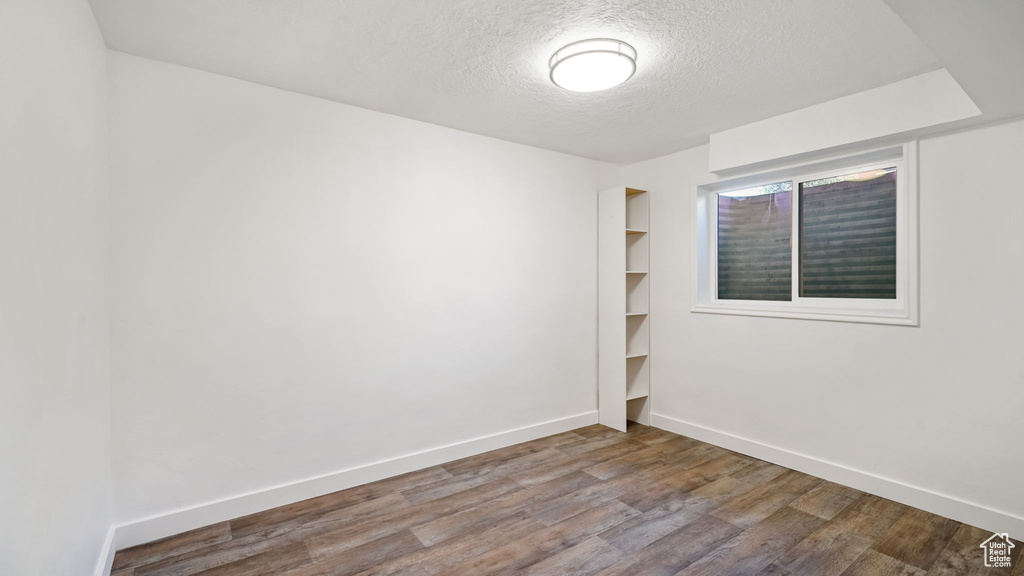 Spare room featuring a textured ceiling and wood finished floors