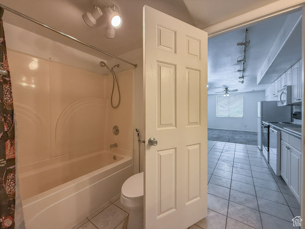 Full bath with shower / washtub combination, tile patterned floors, vanity, and rail lighting