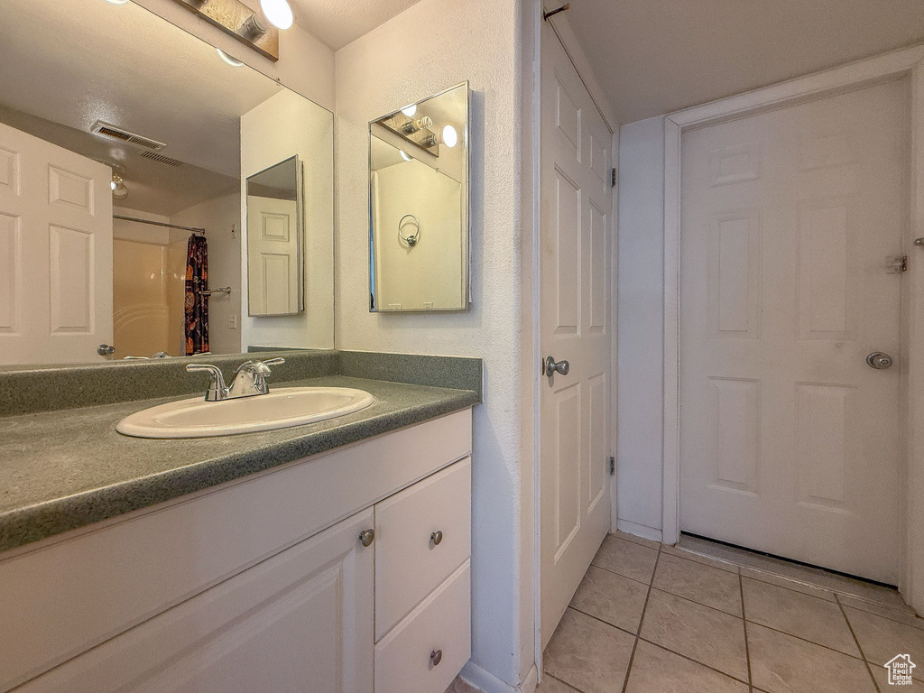 Full bath featuring vanity and tile patterned flooring