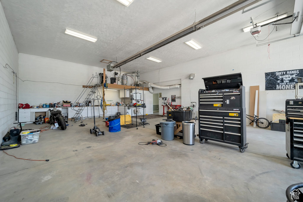 Garage featuring a workshop area and a garage door opener
